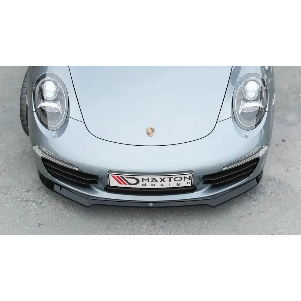 Front splitter på Porsche 911 Carrera 991 med svart Maxton Design-frontspoiler og synlig emblem.