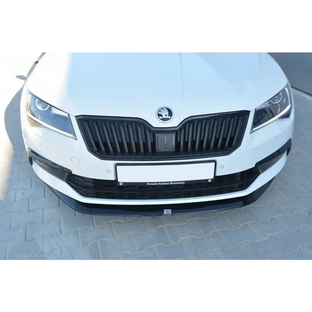 Spoiler til Skoda Superb III V.1 sett forfra med svart grill, frontlykter og synlig skiltbrakett.