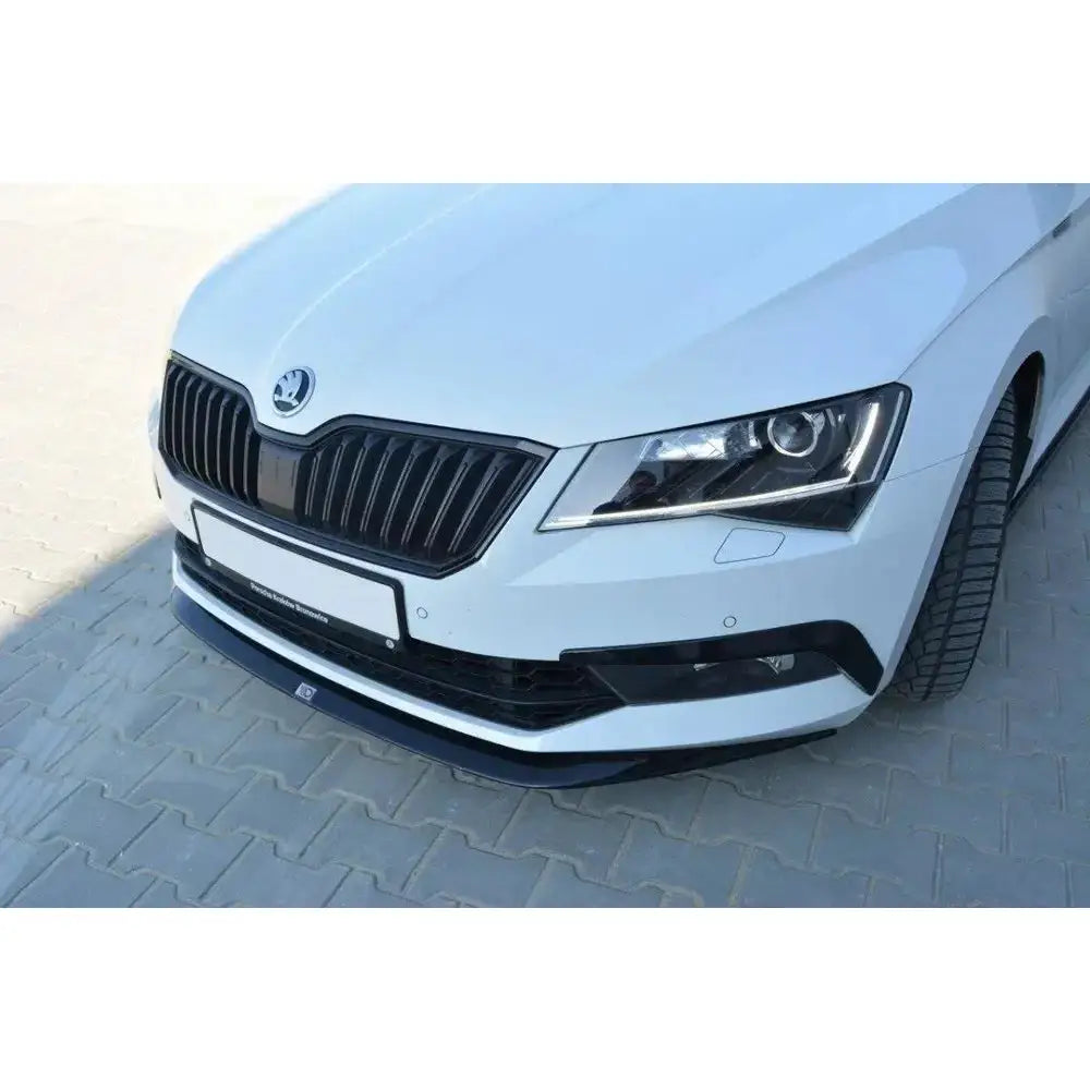 Front splitter på Skoda Superb III V.1, hvit bil med sort plastleppe på nedre støtfanger.
