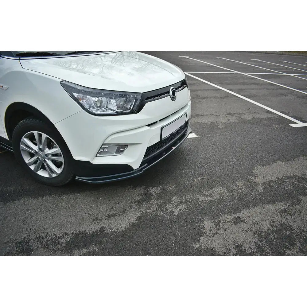 Spoiler på hvit Ssangyong Tivoli V.1, nærbilde med svarte detaljer i tomt parkeringsområde.