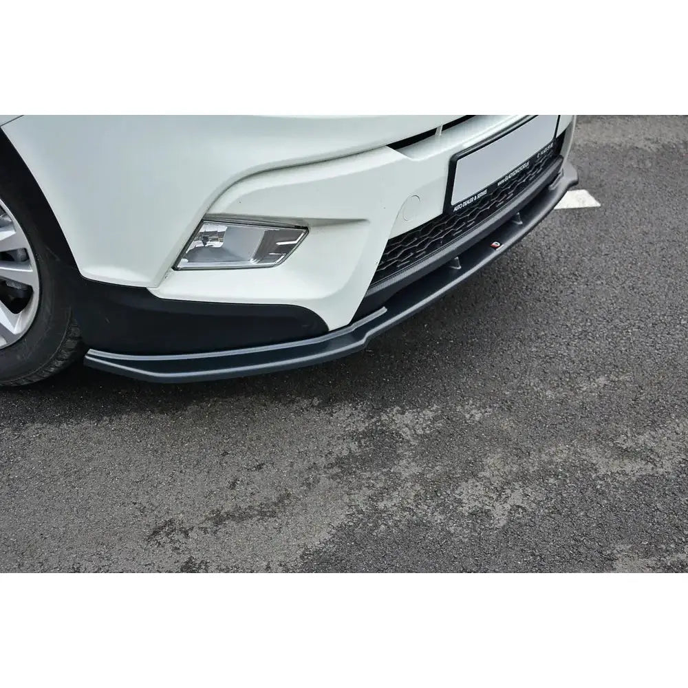 Front splitter til Ssangyong Tivoli V.1 montert under hvit bilfront, sort plast følger støtfangerens form.