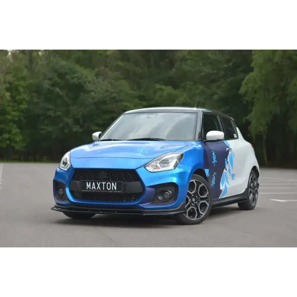Frontleppe på Suzuki Swift 6 Sport V.1 med blå og hvit design, sorte felger og dekalkunst, skrå forside.