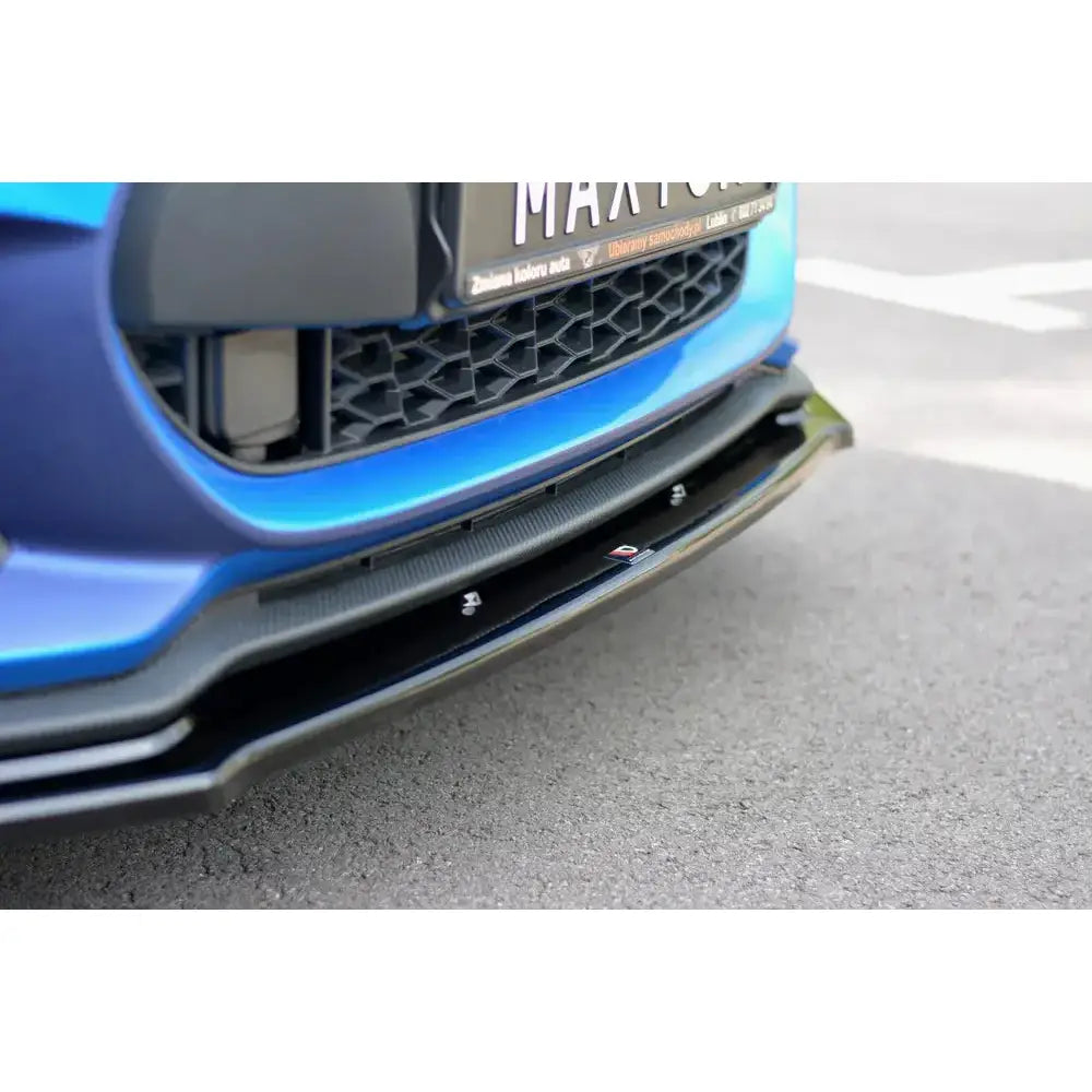 Spoiler til Suzuki Swift 6 Sport V.1 montert på blå bil med sort grill, sett fra skrå vinkel mot bakken.