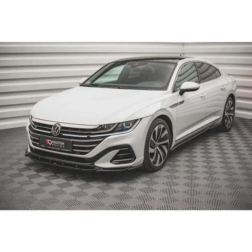 Spoiler til Volkswagen Arteon R-Line Facelift, hvit bil med sorte detaljer sett forfra på rutet gulv.