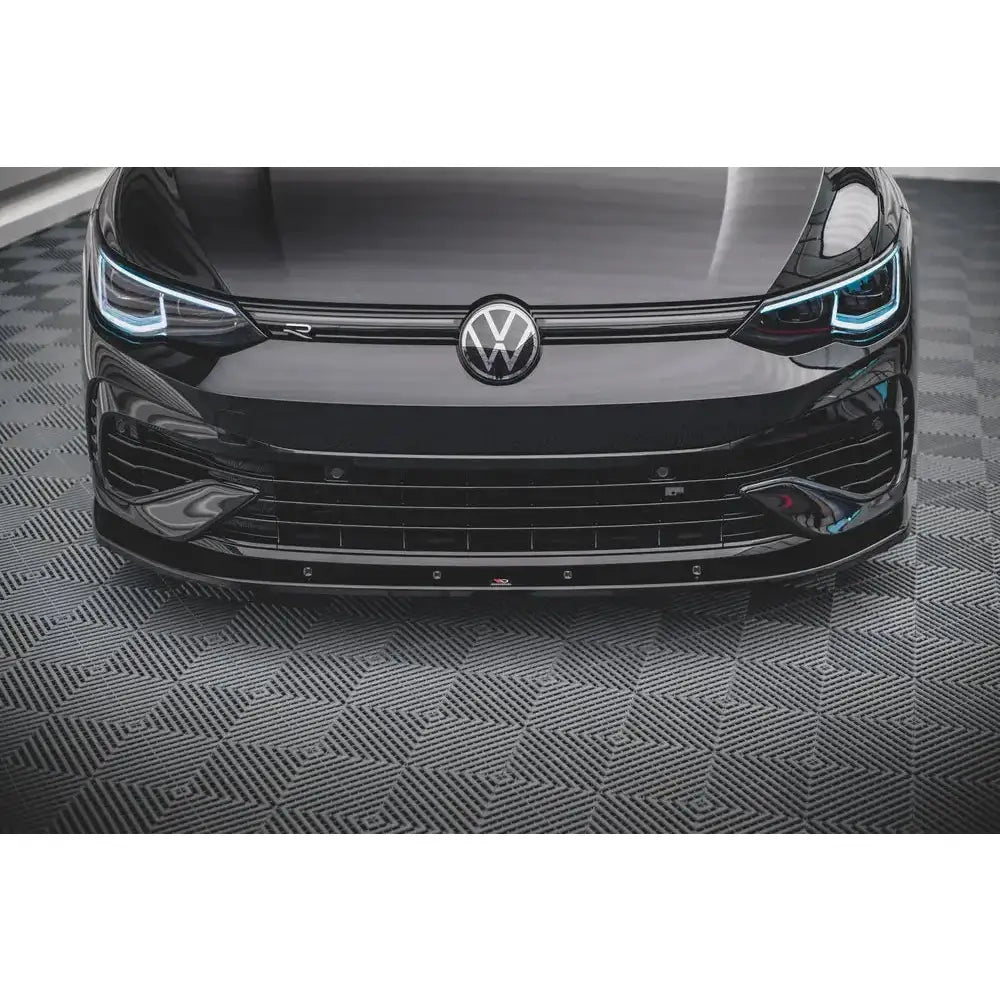 Spoiler til Volkswagen Golf R Mk8 V.1, sort blank finish, LED-lykter og kromlogo sett forfra.