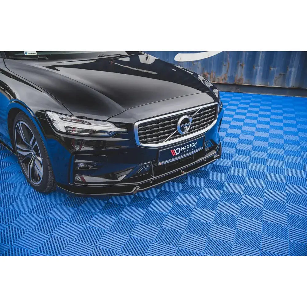 Frontleppe på Volvo S60 R-Design Mk3, sort bil skrått forfra med grill på blått rutete gulv.