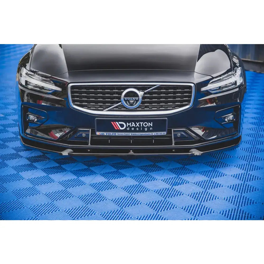 Spoiler på Volvo S60 R-Design Mk3, sort frontspoiler og grill, bilen står på blått mønstret gulv.
