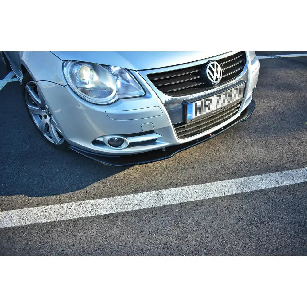 Frontleppe på VW Eos V.1, sort frontsplitter montert under sølvfarget støtfanger på parkeringsplass.
