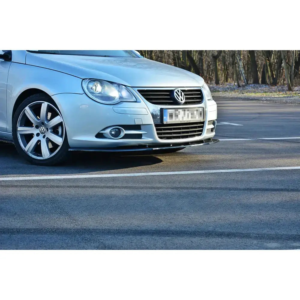 Front lip på VW Eos V.1, nærbilde av sølvfarget bilfront med aluminiumsfelger på asfalt.
