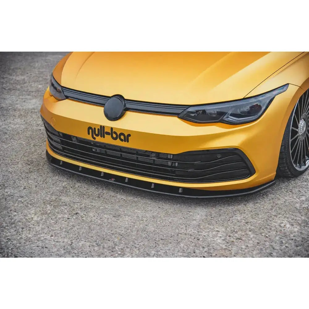 Front splitter på VW Golf 8 V.1 i gul med svart grill, emblemdeksel og synlig Null-bar-logo.