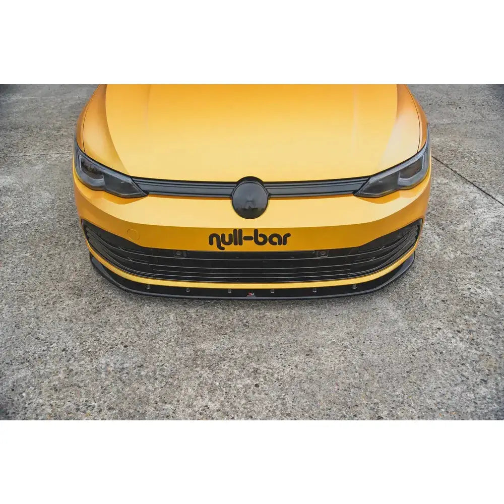 Front lip på gul VW Golf 8 V.1 med svart grill og null-bar logo på panseret, sett ovenfra.