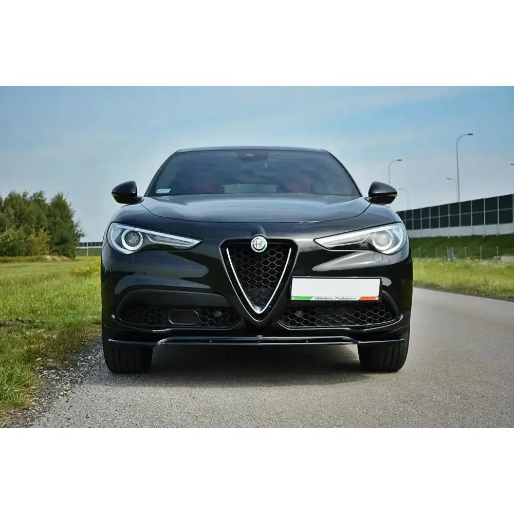 Frontleppe på Alfa Romeo Stelvio V.2 sett forfra med sort grill og kromdetaljer på asfaltert vei.