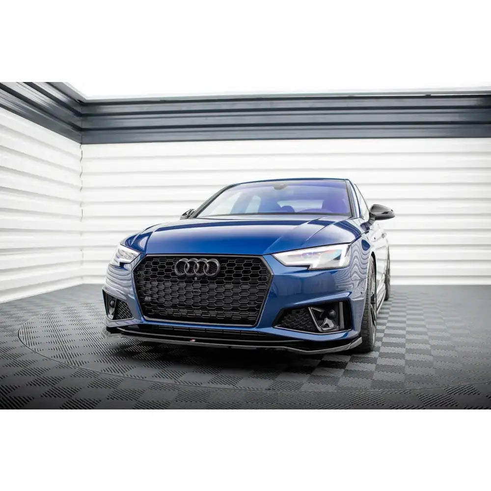 Front splitter på Audi A4 B9 V.2 Competition med sort grill og LED-lykter i lyst studio.