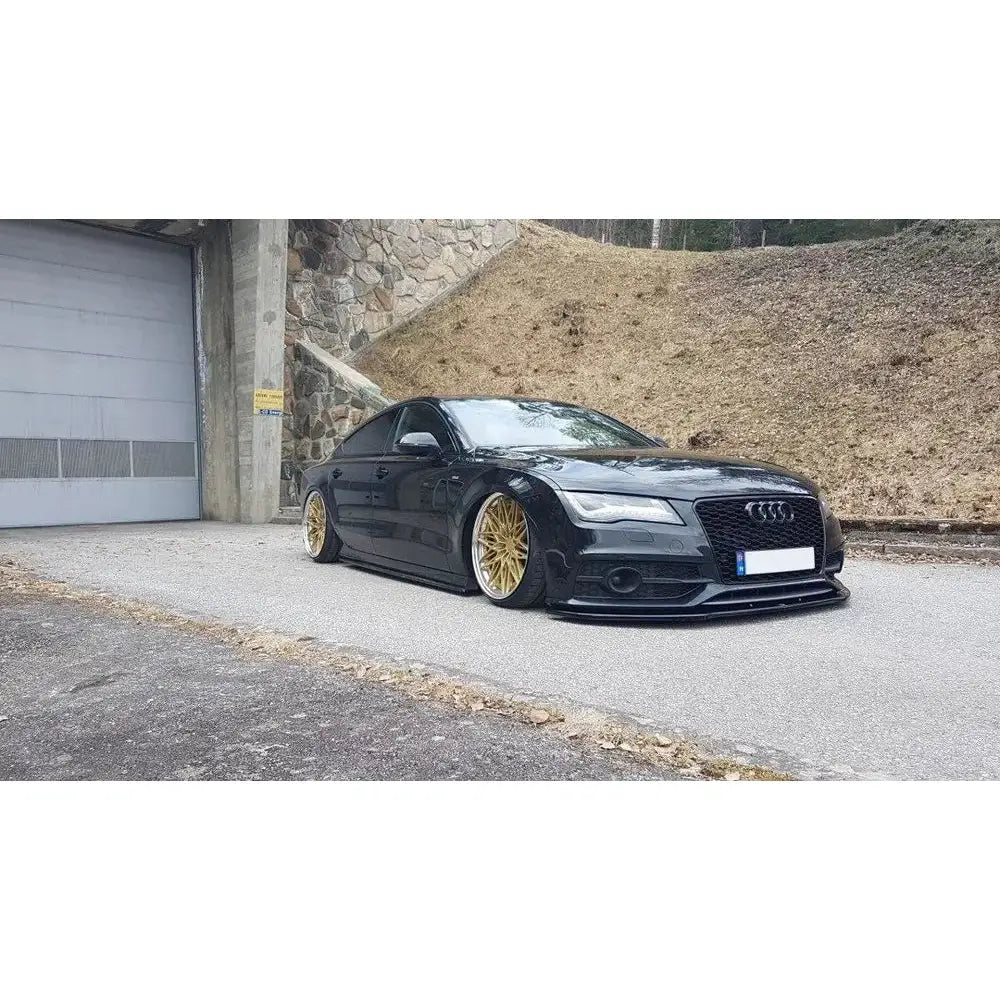 Front splitter på Audi A7 V.2 Mk1 S-Line med gullfelger og lav bakkeklaring, parkert ved steinmur.