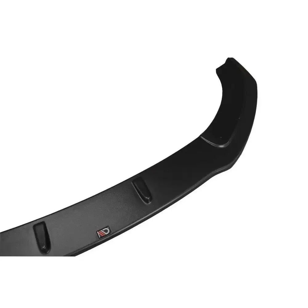 Frontspoiler Audi A7 V.2 Mk1 S-Line i svart plast med forhøyninger og rød-sølv logo, sett fra skrå vinkel.