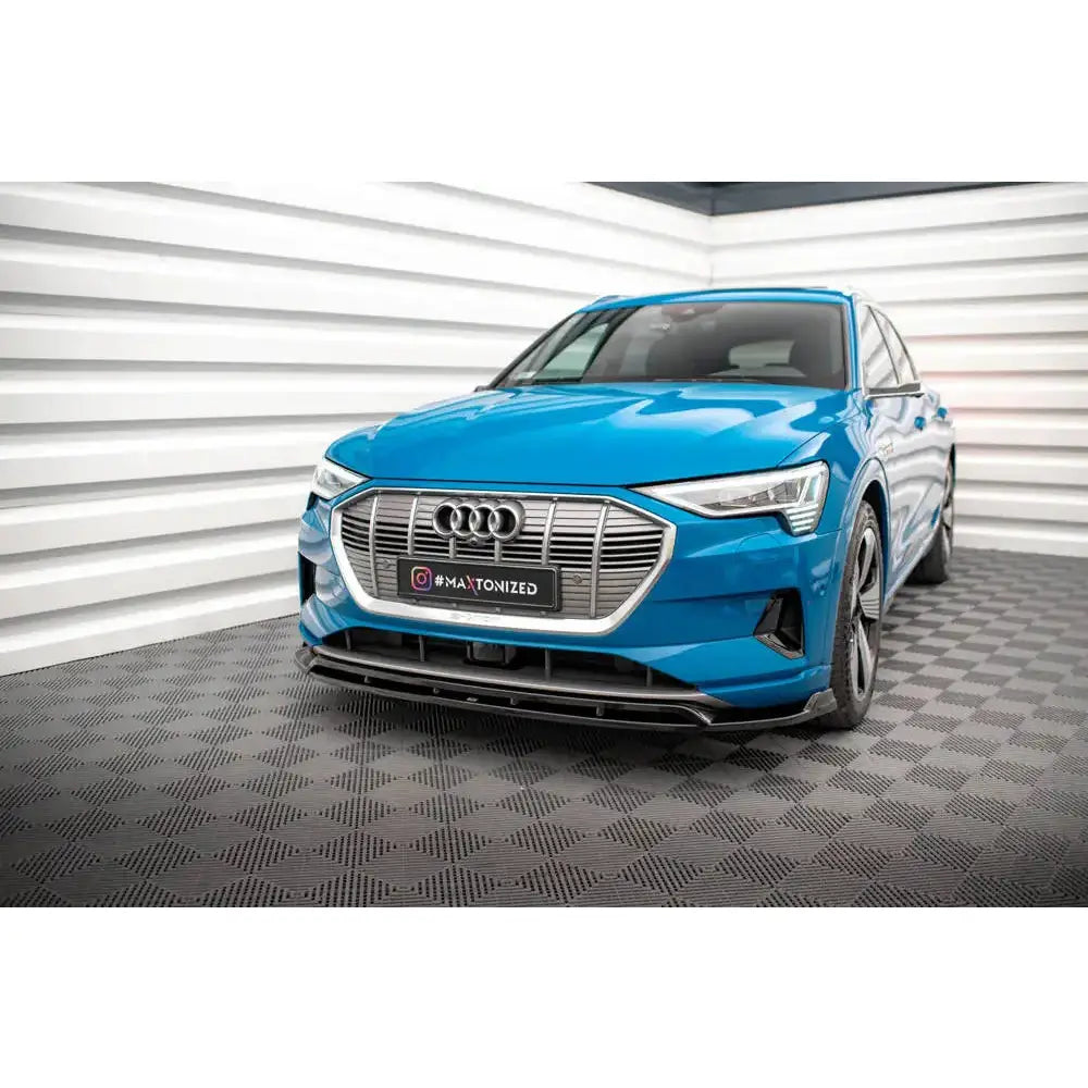Frontsplitter på Audi e-Tron V.2 med sølv grill og sorte detaljer, sett skrått forfra på rutegulv.
