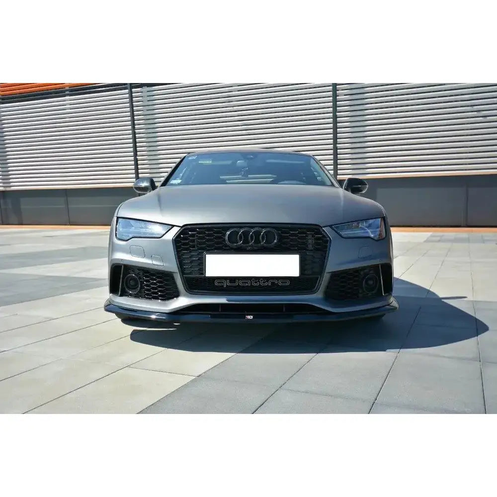 Spoiler Audi RS7 Facelift V.2 sett forfra med sort grill, LED-lykter og karbon på steinbelagt uteplass.