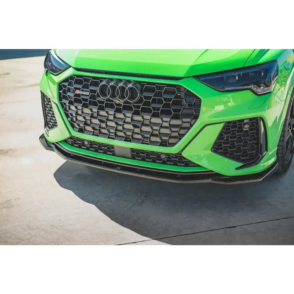 Spoiler Audi RSQ3 F3 V.2 på grønn sportsbil med sort grill og RS-logo, sett fra lav vinkel.