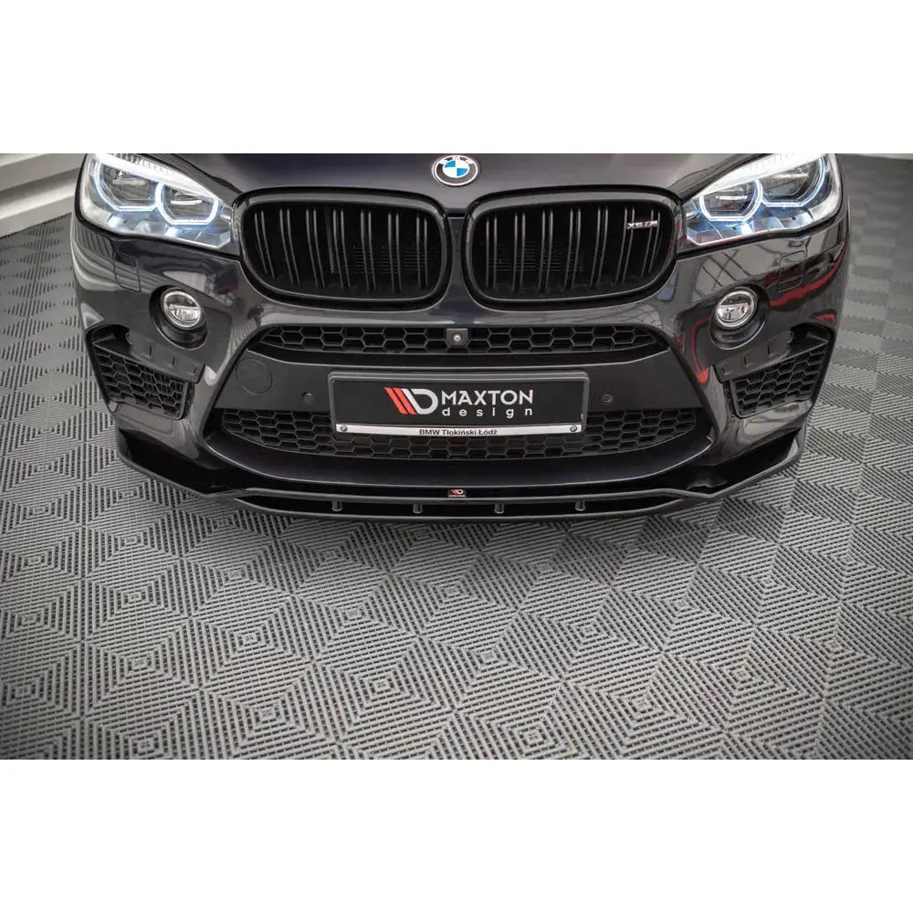 Frontleppe BMW X5 M F15 V.2 i sort blank finish montert nederst på bilens frontstøtfanger.