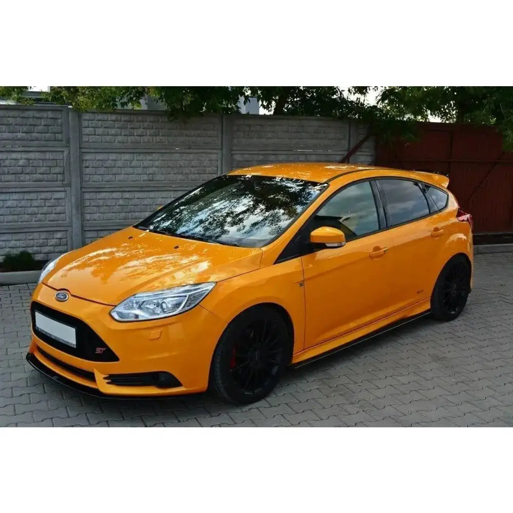Frontleppe på Ford Focus Mk3 St Preface oransje kombi med svarte felger, parkert foran murvegg.