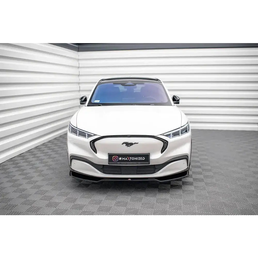 Frontleppe på Ford Mustang Mach-E Mk1 V.2, hvit bil sett forfra med svart grill og LED-frontlykter.