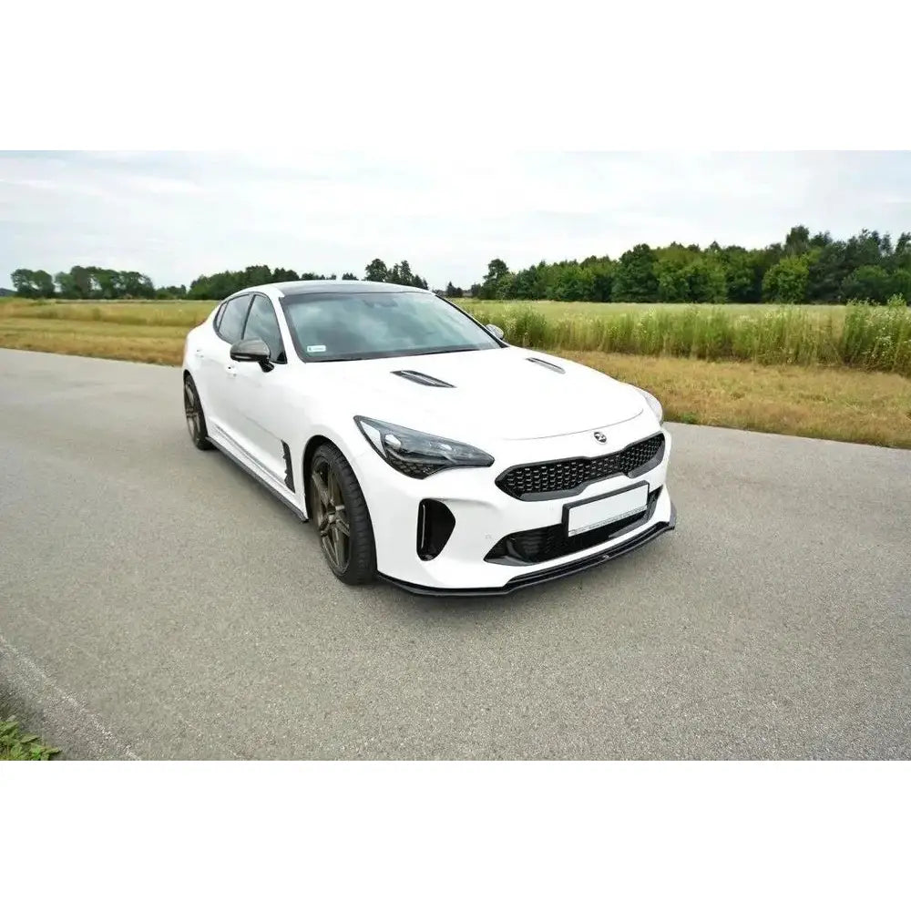Spoiler til Kia Stinger GT V.2 montert på hvit bil med svarte detaljer, fotografert utendørs.