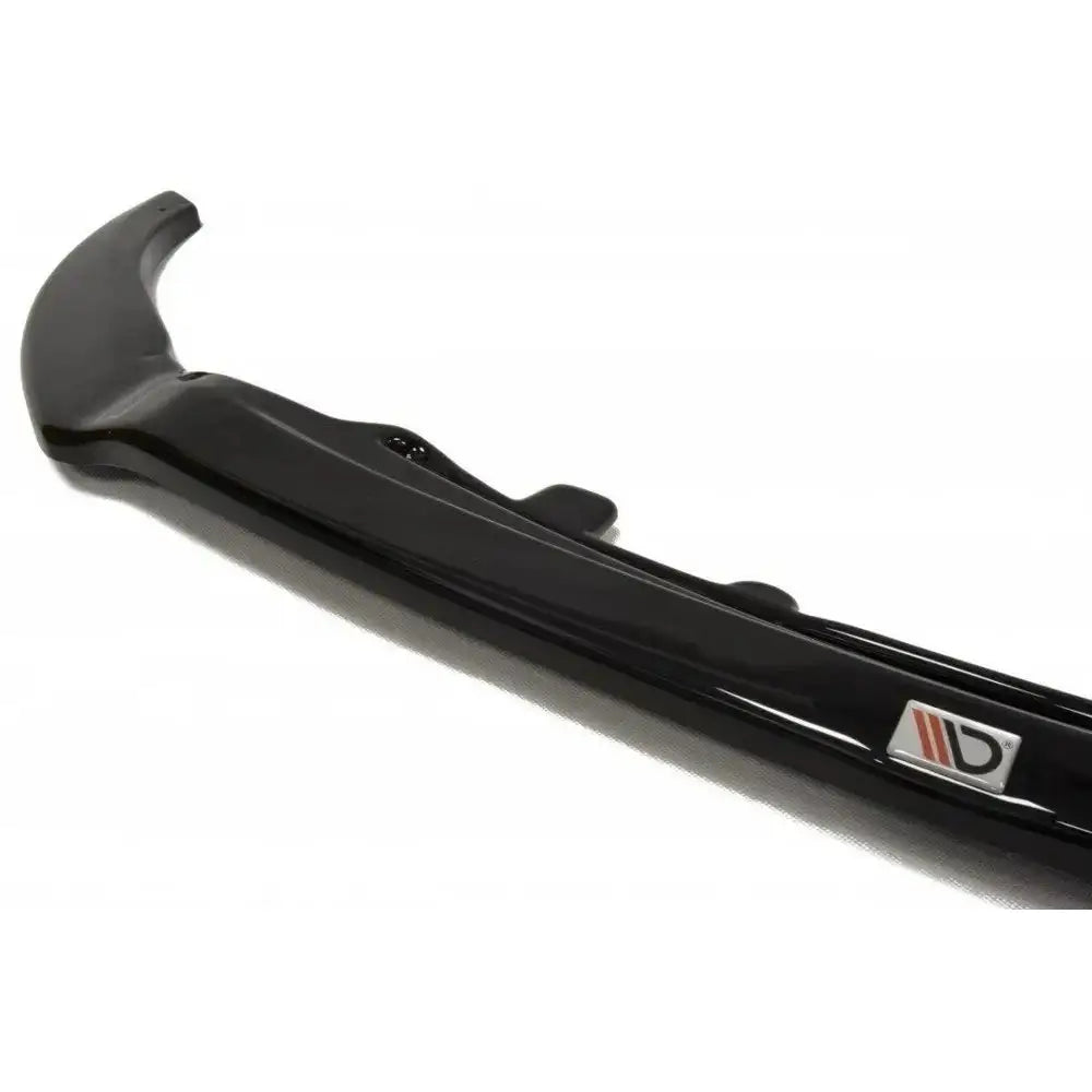 Front lip av sort Mazda Mx-5 IV V.2 spoiler med glanset finish og rødt og sølv emblem i nærbilde.