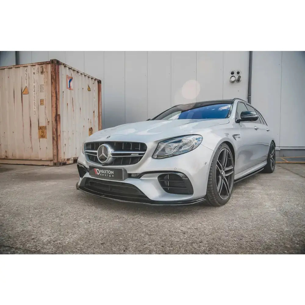 Frontspoiler på Mercedes-Benz E63 AMG Estate S213 med mørke felger sett forfra på asfalt.