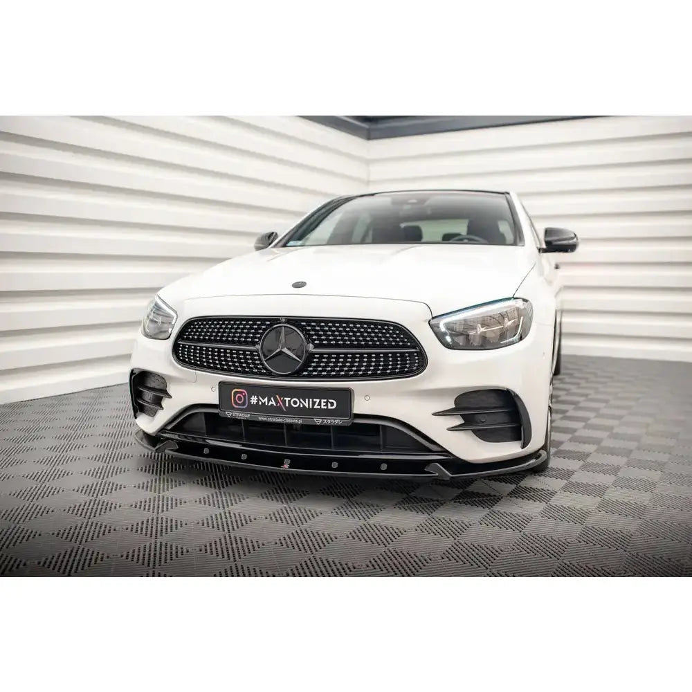 Front splitter på hvit Mercedes E-Klasse W213 AMG-Line Facelift med sort grill og mørke luftinntak.
