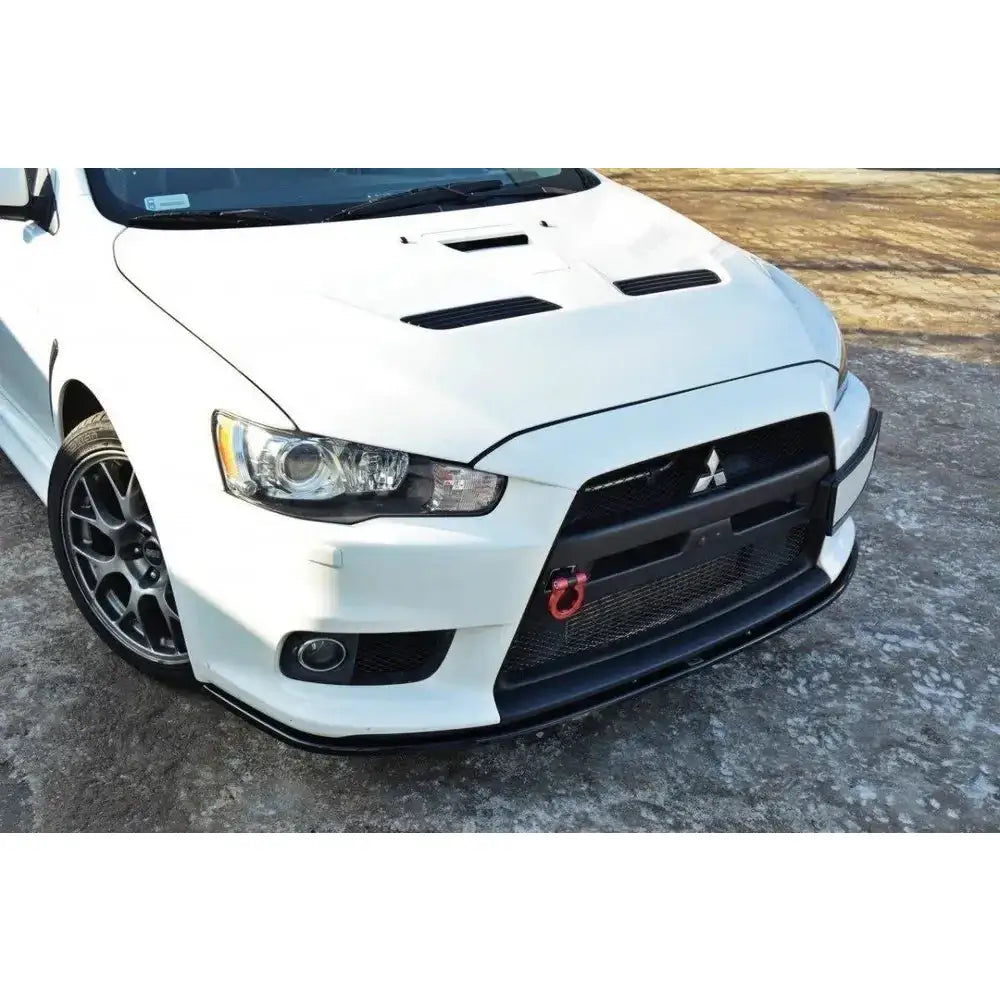 Spoiler på Mitsubishi Lancer Evo X V.2, hvit bil med sort grill, rød slepekrok og sporty støtfanger.