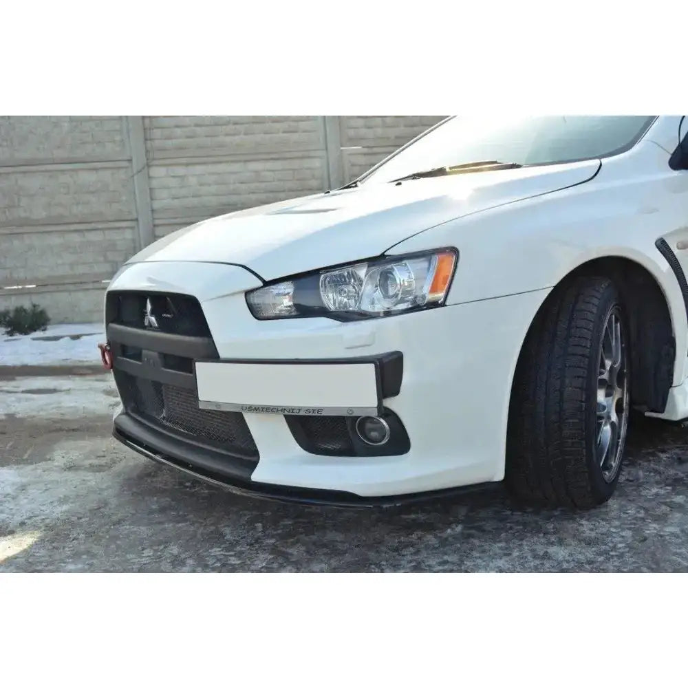 Front lip på Mitsubishi Lancer Evo X V.2, svart frontsplitter på hvit bil i snø.