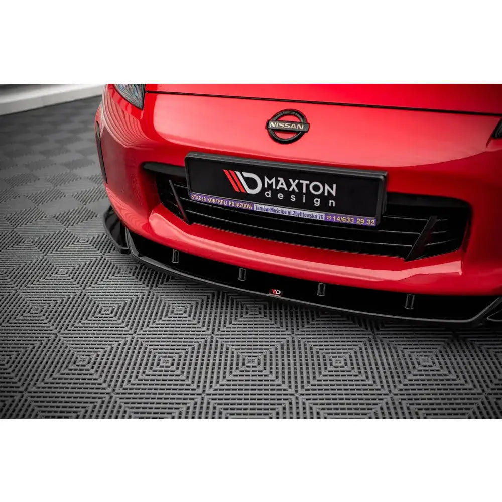 Front splitter til Nissan 370Z Facelift V.2, sort med Maxton Design-skilt på rød bil, sett forfra.