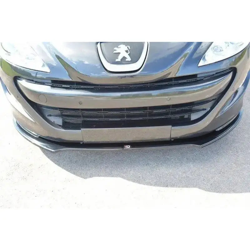 Frontleppe til Peugeot RCZ V.2, sort plast montert under støtfanger, krommerke synlig foran.