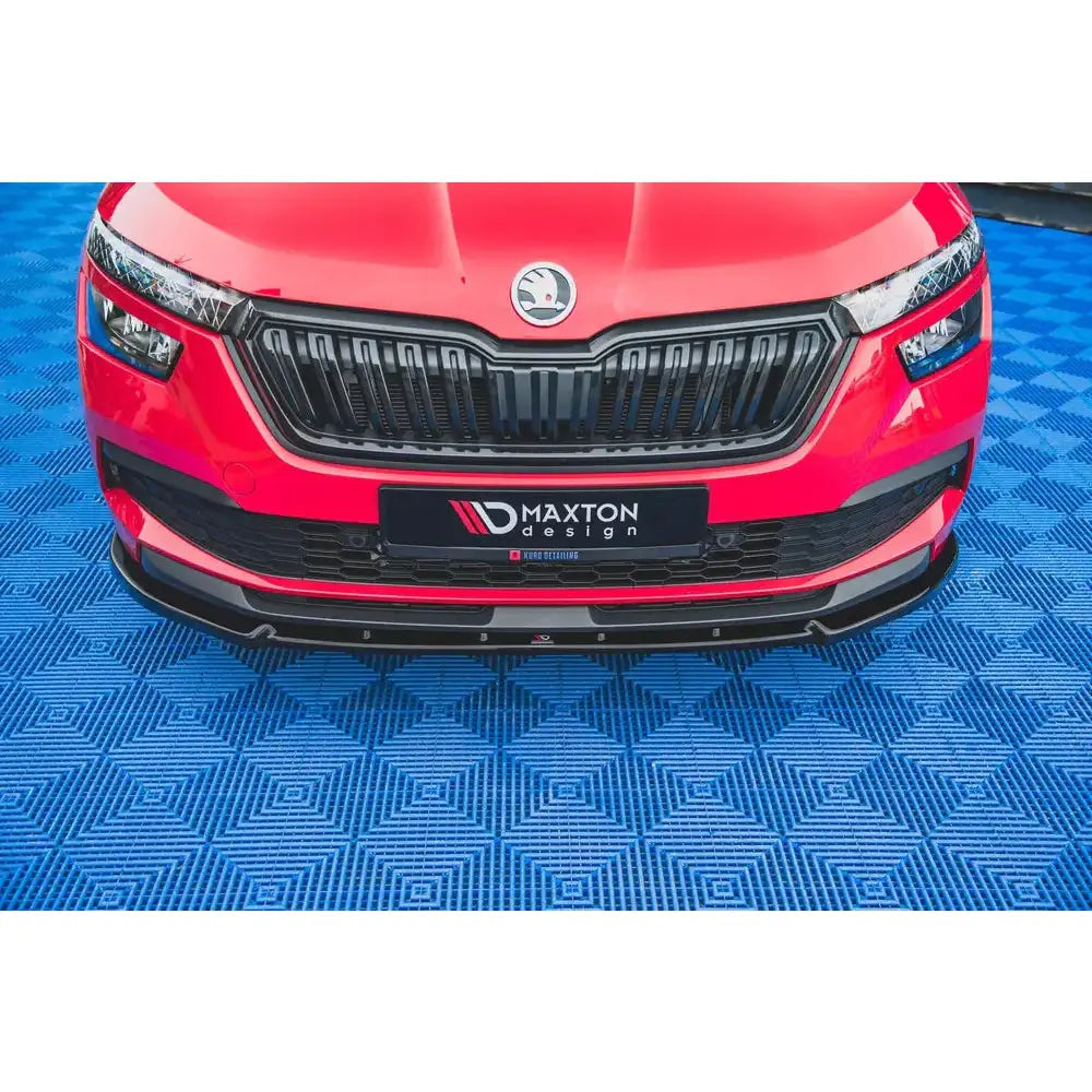 Spoiler til Skoda Kamiq V.2 montert på rød bil med svart grill og blank sort frontsplitter, sett forfra.
