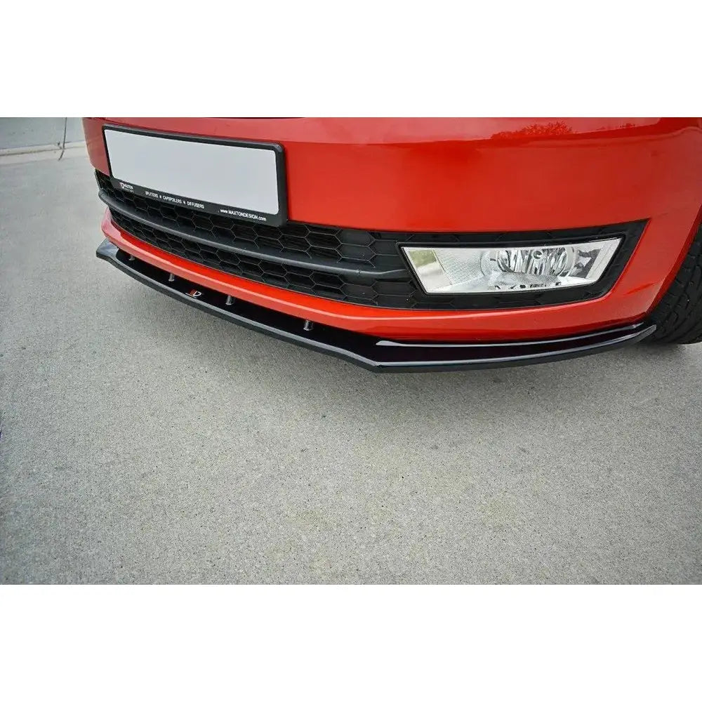 Front splitter til Skoda Rapid V.2 i svart plast montert under rød frontfanger, sett skrått forfra.