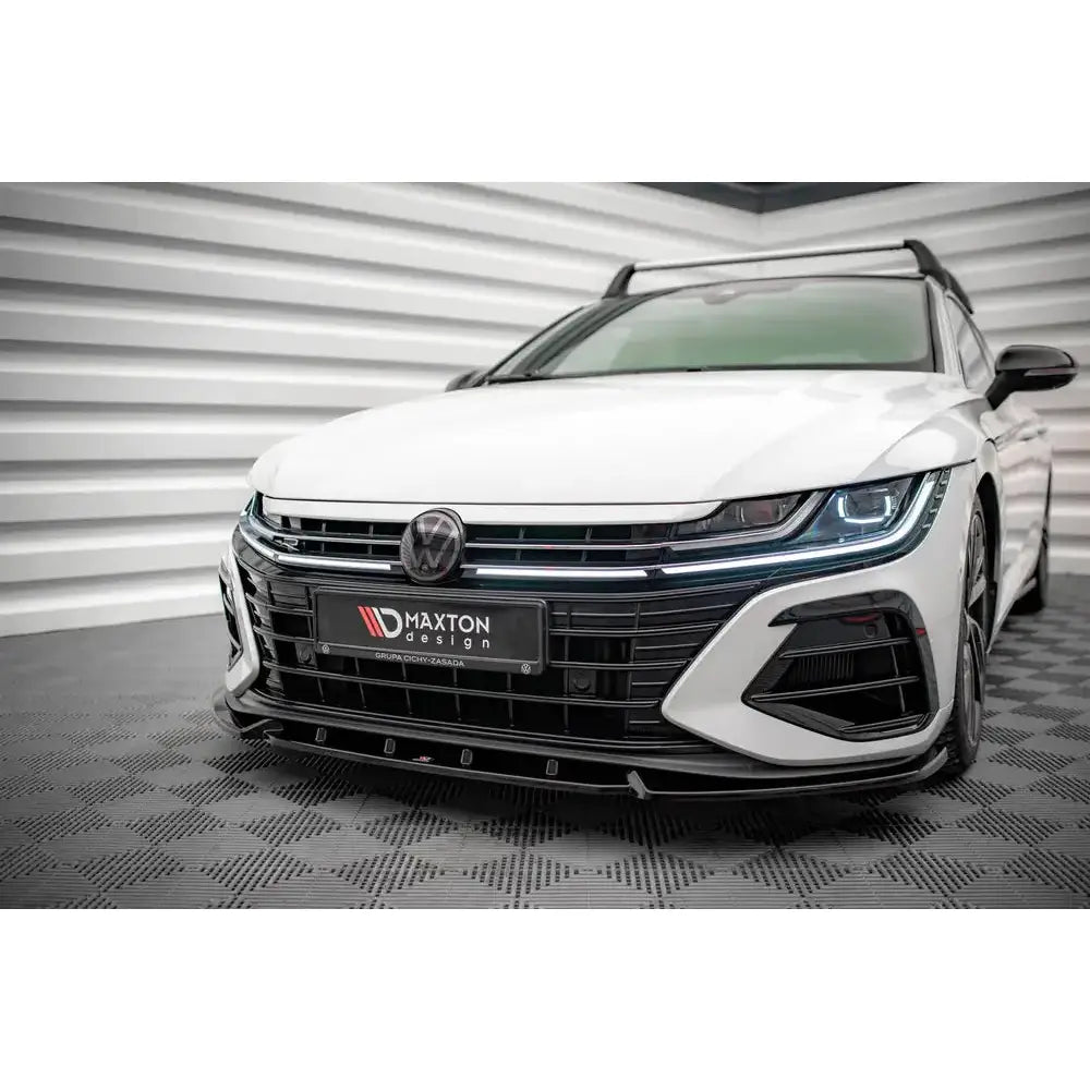 Front splitter på Volkswagen Arteon R med svart Maxton Design-grill og markerte frontlys i lyst miljø.