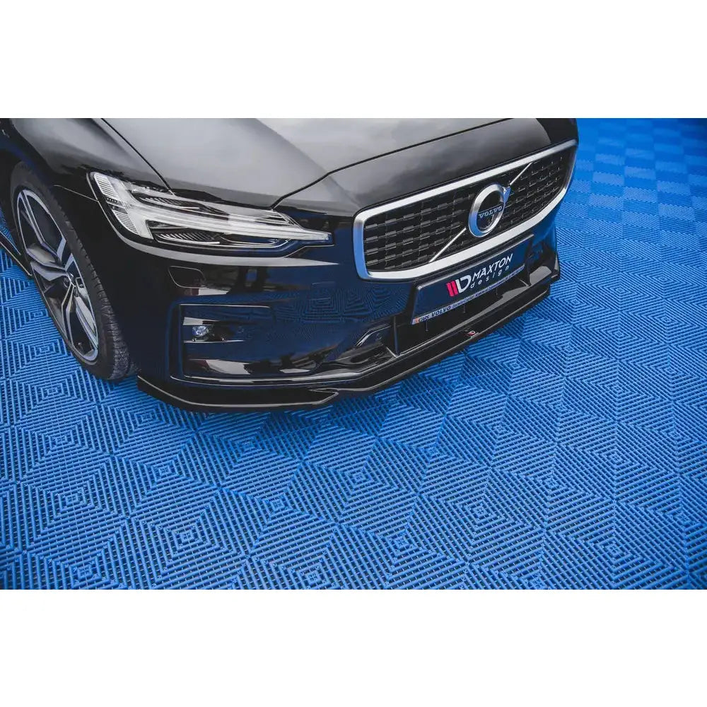 Spoiler til Volvo S60 R-Design Mk3 V.2 sett fra skrå vinkel med synlig grill på blått gulv.