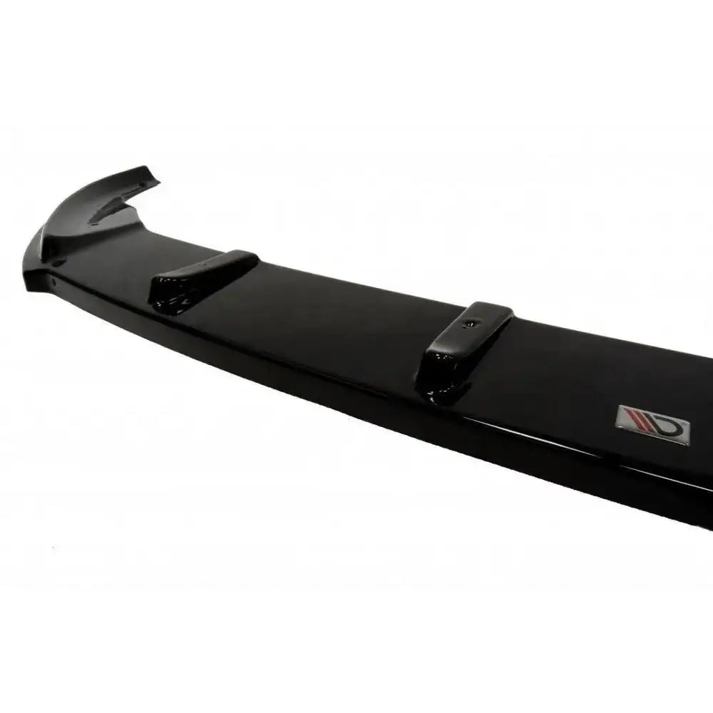 Spoiler til VW Golf VII V.2 i sort blank plast sett fra skrå vinkel med monteringsfester og logo.