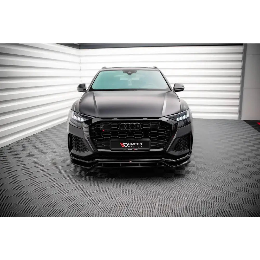 Frontspoiler på Audi RSQ8 Mk1 19- sett forfra med markant grill og LED-lys i lyst rom.