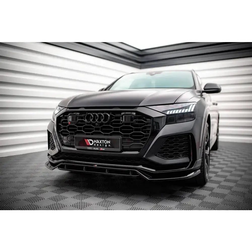 Front splitter på Audi RSQ8 Mk1 SUV med markant grill og LED-frontlykter, innendørs mot stripete vegg.