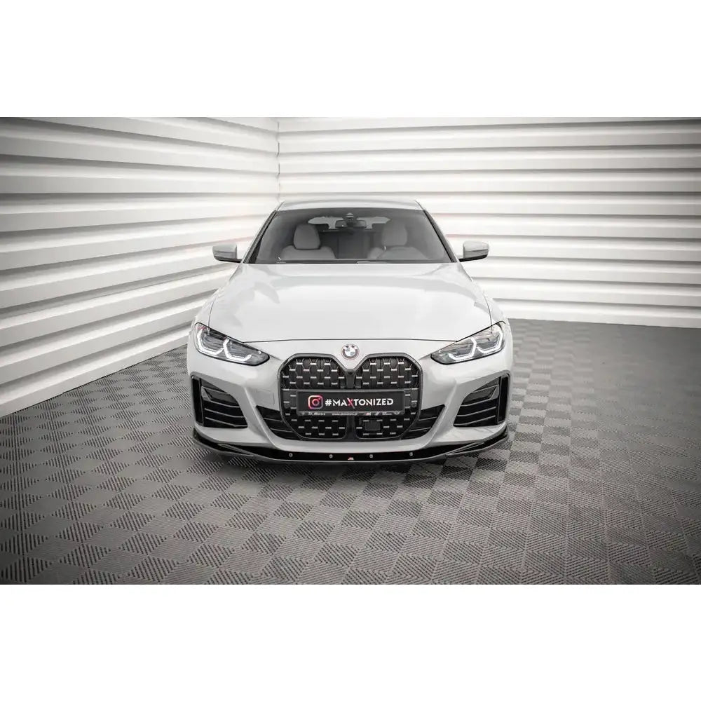 Frontleppe BMW 4 Gran Coupe M-Pack G26 V.3 på hvit bil sett forfra med sort grill og brede luftinntak.