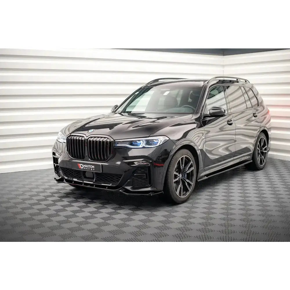 Frontleppe på BMW X7 M G07 V.3 18-, svart SUV med blå frontlyktdetaljer i lyst innemiljø.