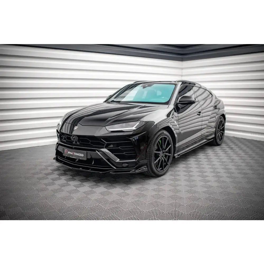 Front splitter på Lamborghini Urus Mk1 med sort lakk, store felger og sportslig design i lyst rom.