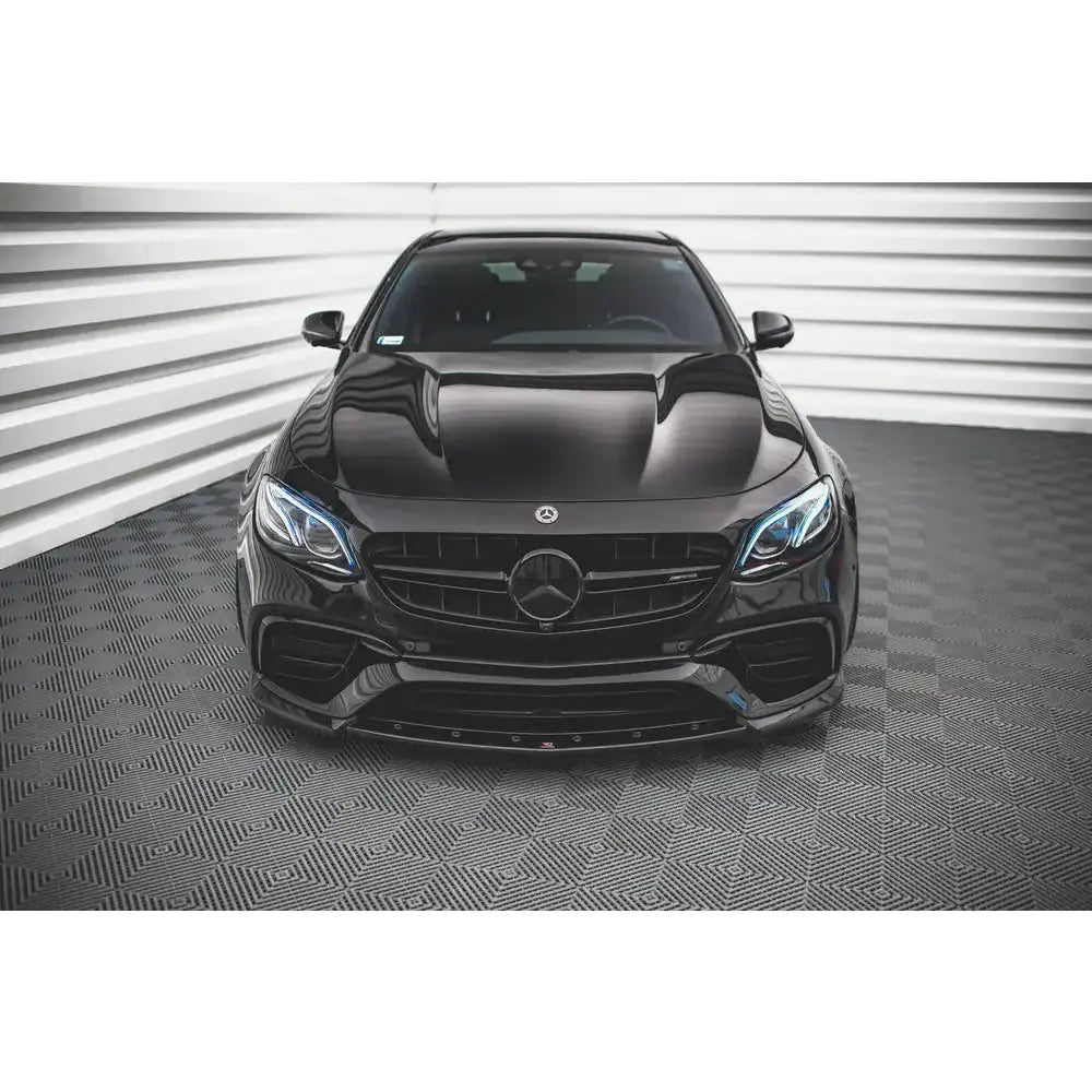 Frontspoiler på Mercedes-Benz E63 AMG S213/W213 sett forfra med markerte lykter og blank finish.