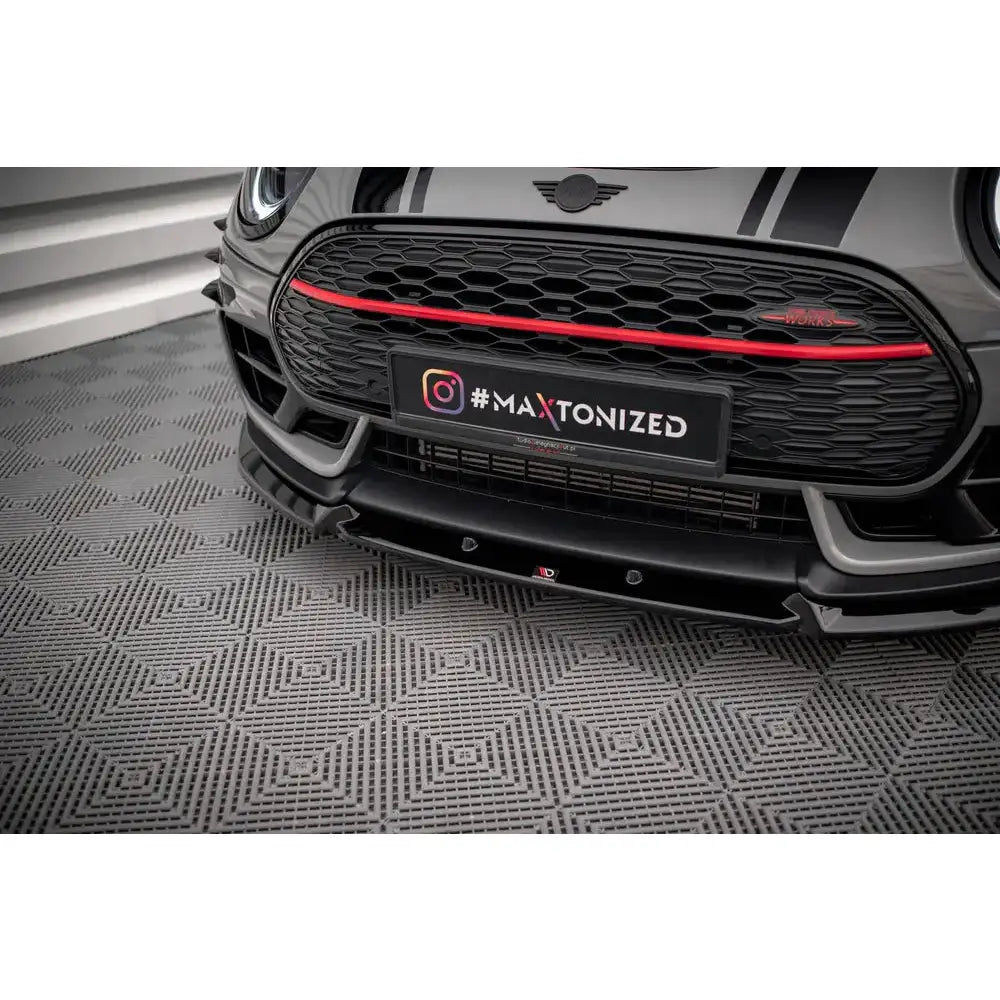 Spoiler på Mini Cooper Clubman John Cooper Works F54 med svart grill og rød stripe, sett forfra.