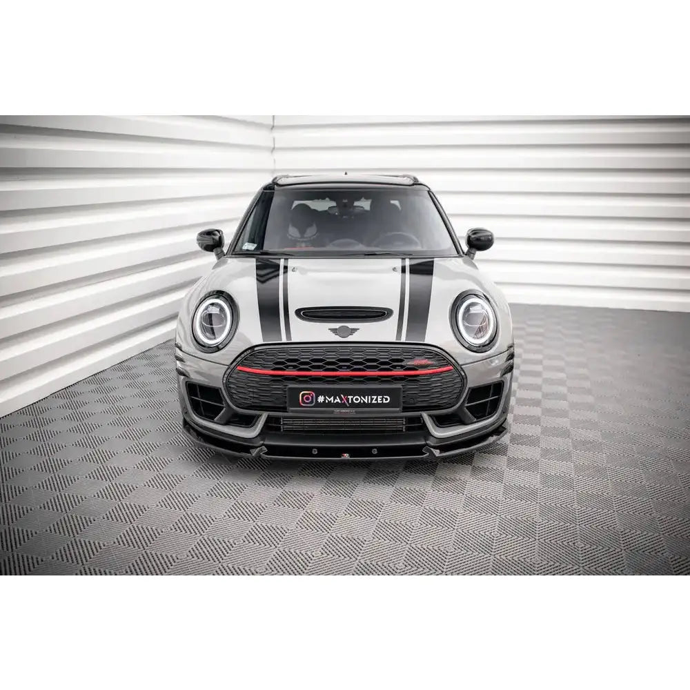 Front splitter på Mini Cooper Clubman John Cooper Works F54, sett rett forfra med svarte striper og rød grilldetalj.