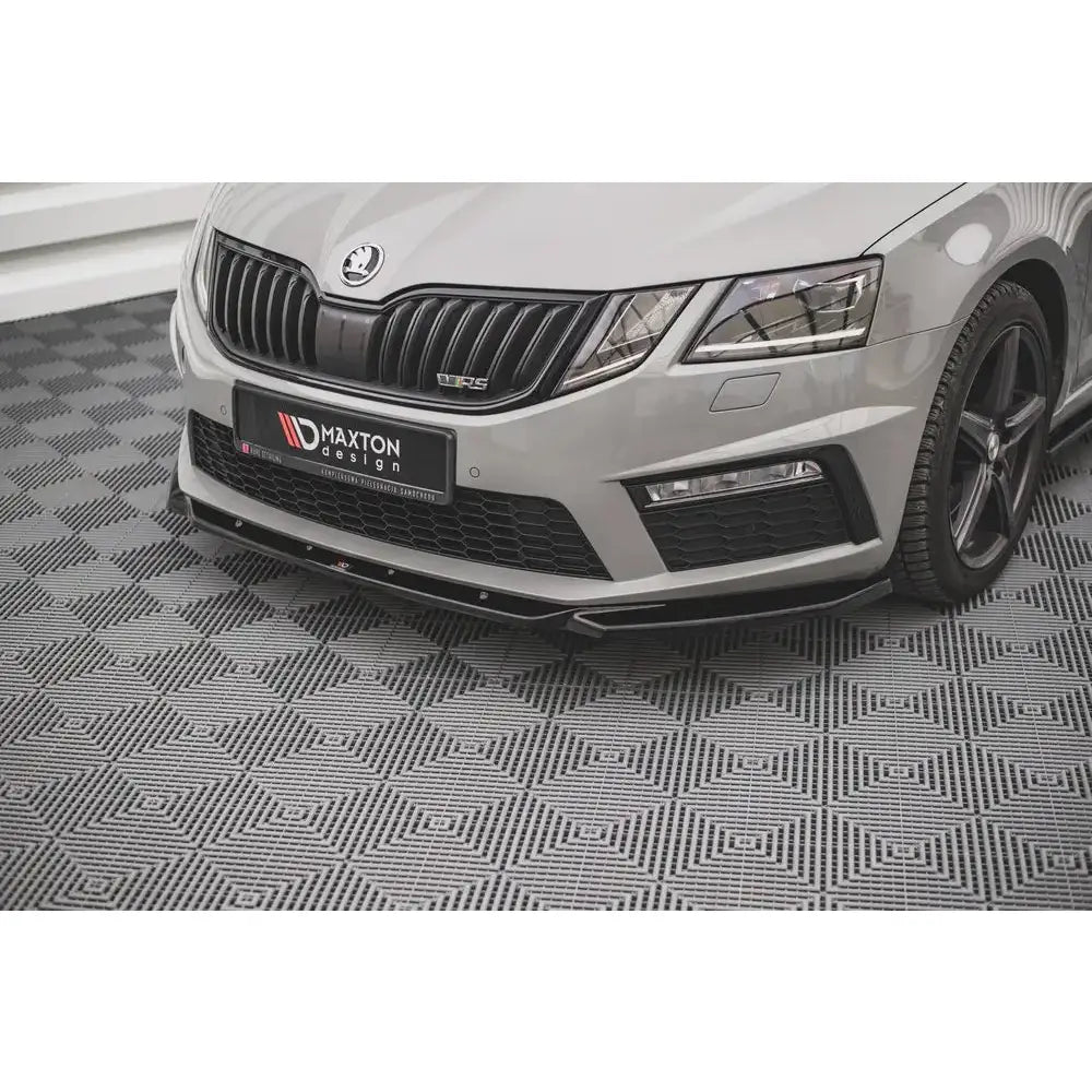 Front splitter på Skoda Octavia RS Mk3 Facelift med sort plastspoiler, sett fra skrå vinkel på mønstret gulv.