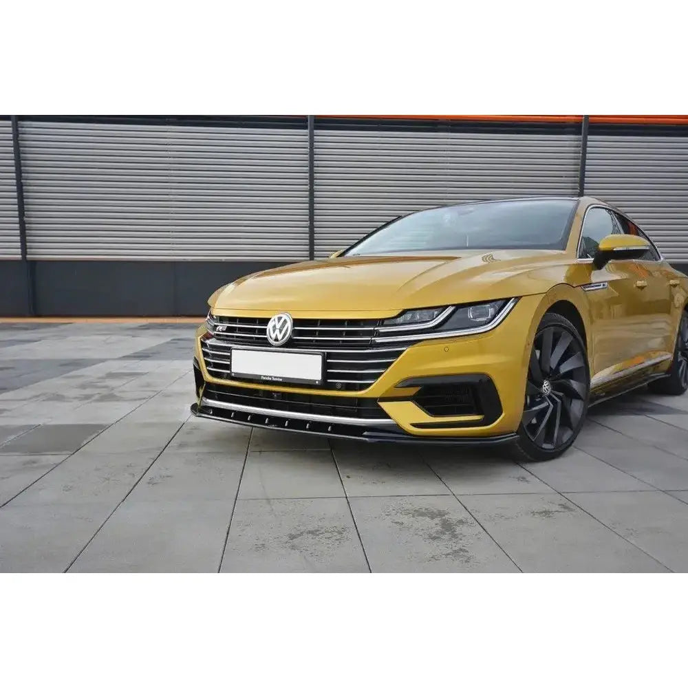 Frontspoiler VW Arteon V.3 på gul bil med svarte detaljer og store felger, sett forfra og litt fra siden.