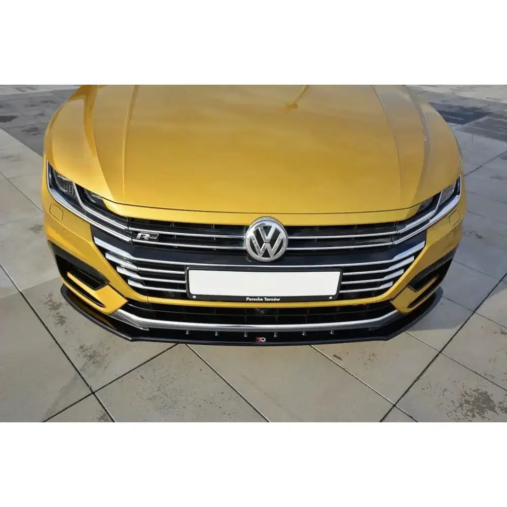 Frontleppe VW Arteon V.3 på gullfarget bil med kromdetaljer, VW-logo og R-emblem, sett forfra.