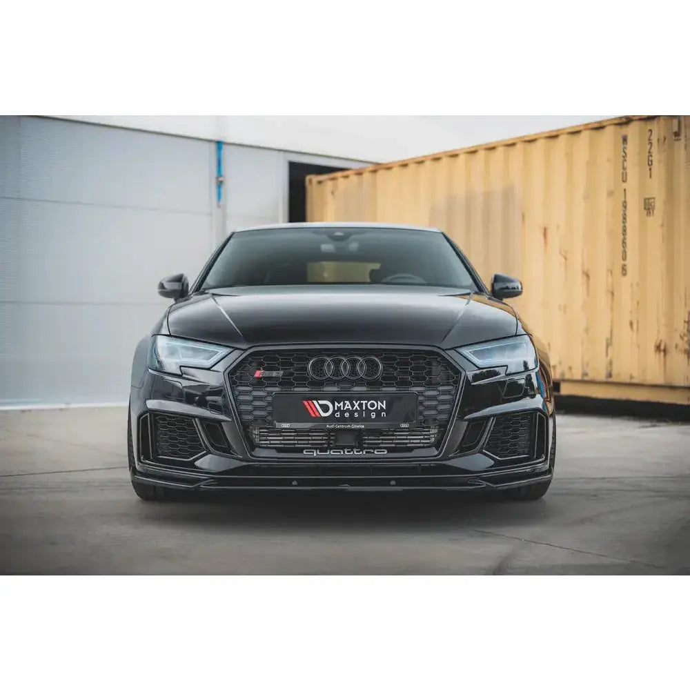 Frontspoiler Audi RS3 8V FL Sportback V.4 montert på sort bil foran gul container.